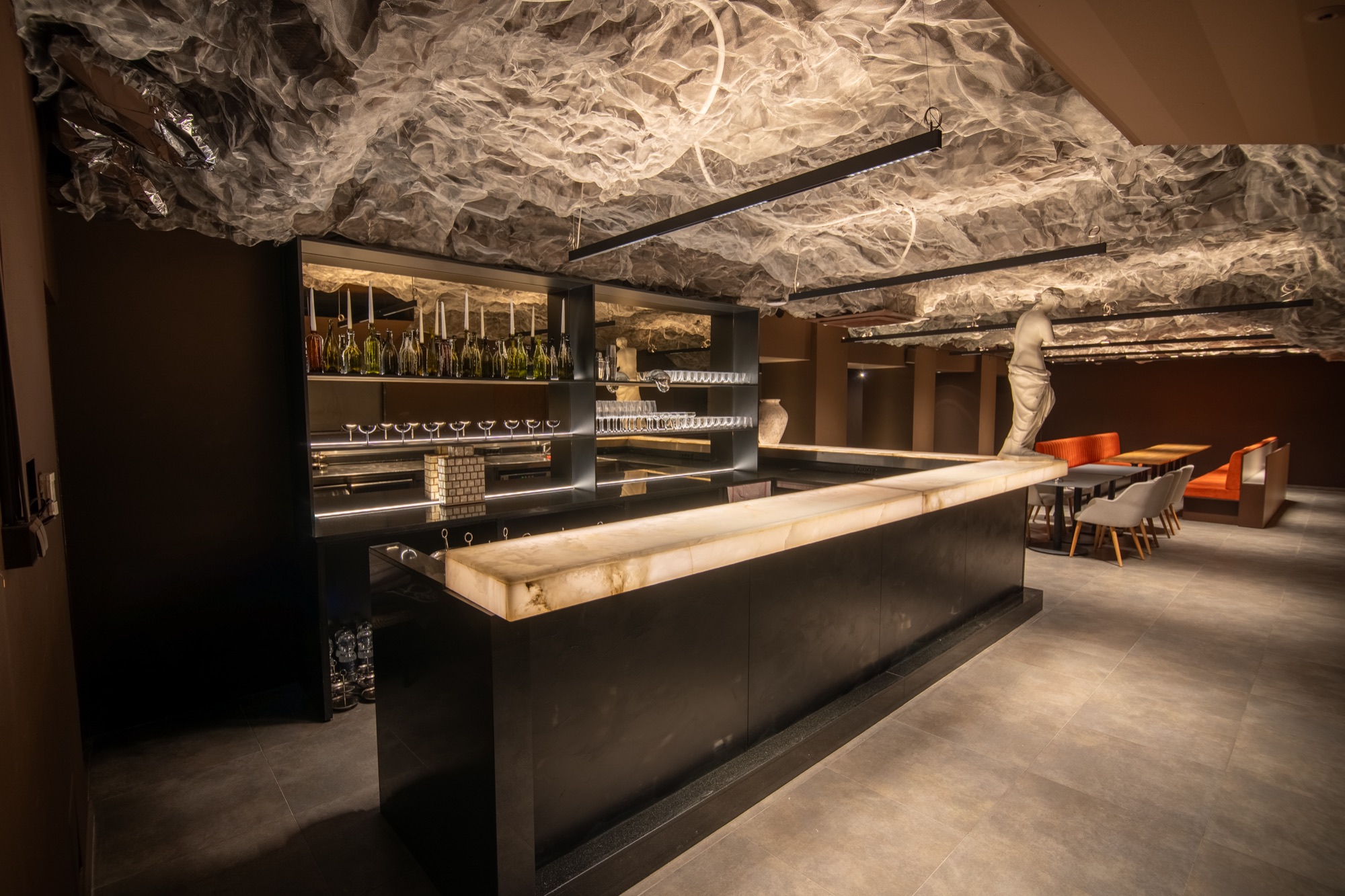 Bar s podsvieteným onyxom a stropná inštalácia